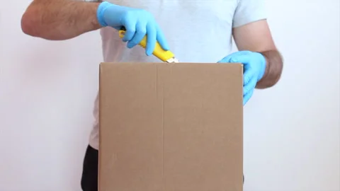 Man opens a cardboard box in blue medical gloves. Unpacking boxes in medical Stock Footage 142191271