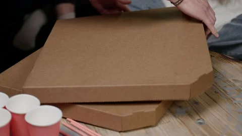Man opens cardboard box. lot of hands reach out, take apart out pizza slices Stock Footage 168583226