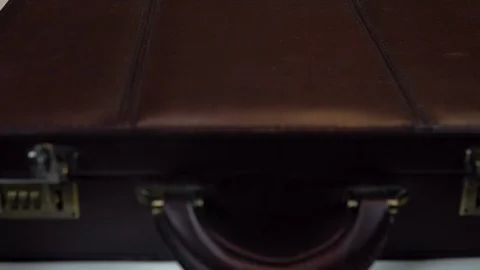 A man opens a case closeup. In an open case are dollars and drugs 库存影片 123734306