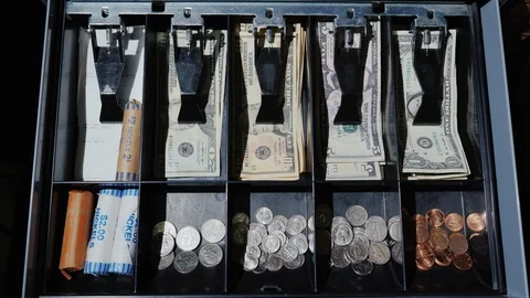 The man opens the cash register. A drawer with cash dollars expands and fills Stock Footage 86986735