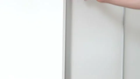 The man opens the closet and returns the shoes to the closet Stock Footage 135808994