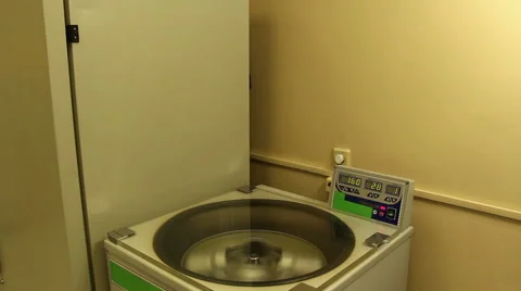 A man opens cover and withdraws glassware from centrifuge Stock Footage 58400724