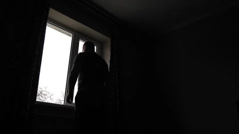 The man opens the curtains and the window. Low angle silhouette shot Stock Footage 263236562