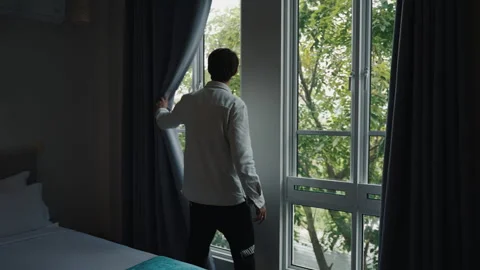 A Man Opens the Curtains in the Room Stock Footage 293277170