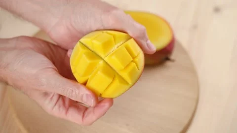 Man opens cut a mango, close up Vidéo 166926166