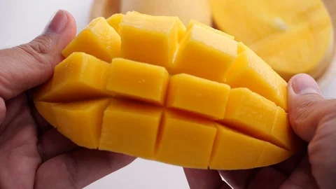 Man opens a cut ripe mango. Fresh Sliced Mango Squared in 4k slow motion Stock-Footage 128160894