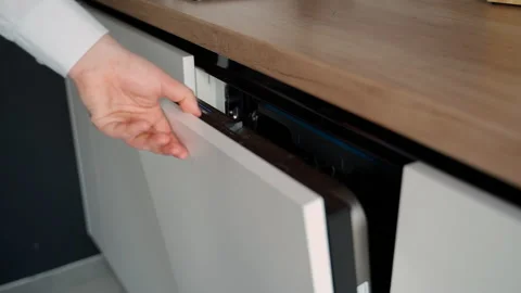 Man opens a dishwasher with a white facade Stock Footage 153281555