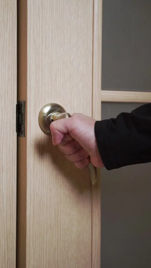 A man opens a door and walks into a room 動画素材 310538818