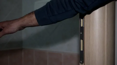 A man opens the door to the bathroom with the handle and goes inside. Stock Footage 237154647