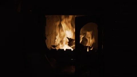 Man opens the door of a burning fire brick stove Stock Footage 100889928