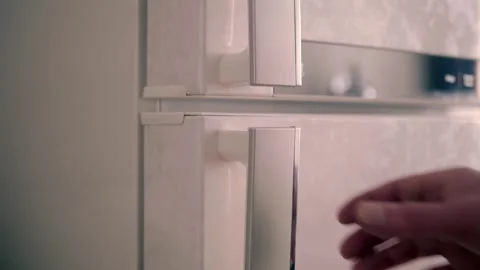 Man opens the door of a modern refrigerator and gets the necessary products Stock Footage 297788411