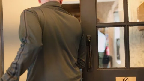 Man Opens Door with Push Sign at Scottish Distillery Entrance Stock Footage 318517594