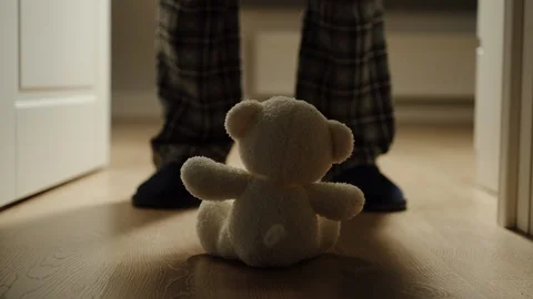 Man Opens The Door In The Room Where Plush Bear Toy Is Sitting Stock Footage 124623497