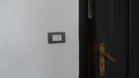 Man opens the door turns on the light and enters the room Stock Footage 101659811