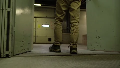 A man opens the doors of a freight elevator in a self-service warehouse and Stock Footage 275339091