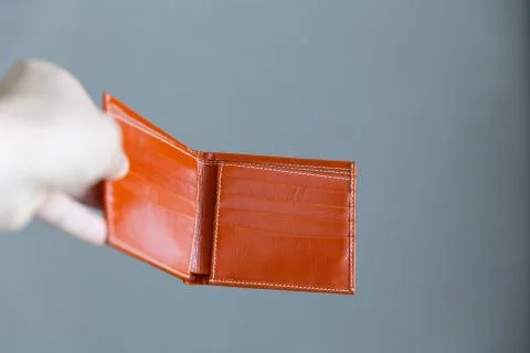 Man opens an empty orange leather wallet. Foto stock