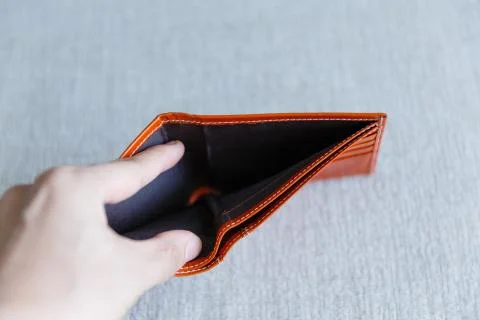 Man opens an empty orange leather wallet. Foto stock