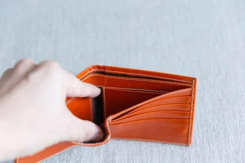 Man opens an empty orange leather wallet. Foto stock