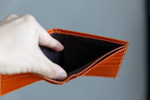 Man opens an empty orange leather wallet. Stock-Fotos
