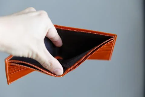 Man opens an empty orange leather wallet. Foto stock