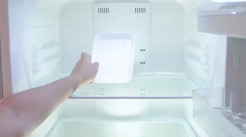 The man opens the empty refrigerator, looking for something in a blank plate Stock Footage
