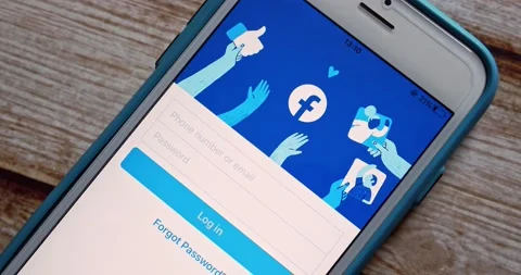 Man opens Facebook app on iPhone. Facebook is an US social media by Meta Stock Footage 207549189