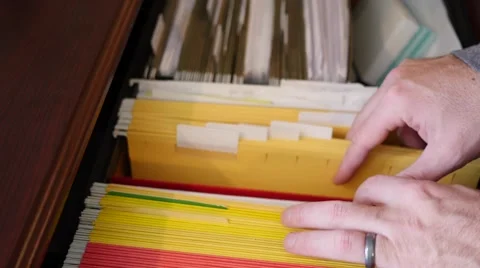 A man opens up a file cabinet and removes file Video stock 58110328