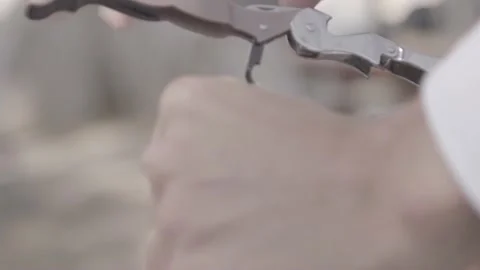 A man opens a fine bottle with a corkscrew and pulls out the cork, closeup Stock Footage 135398407