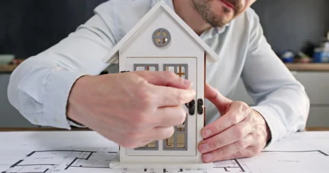 Man opens front door of model to reveal sign with word Vendita Stockbeeldmateriaal 314727003