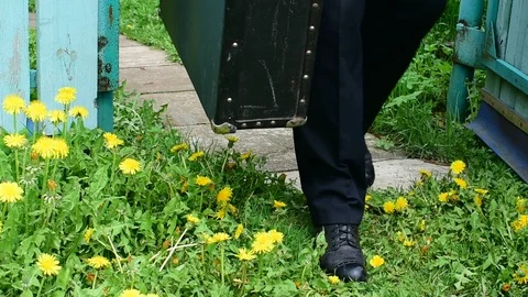 Man opens the gate and leaves with a suitcase Stock Footage 108139003