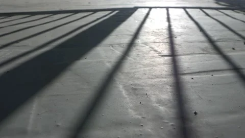 The man opens  gate, a shadow on the concrete floor. Stock Footage 136022580