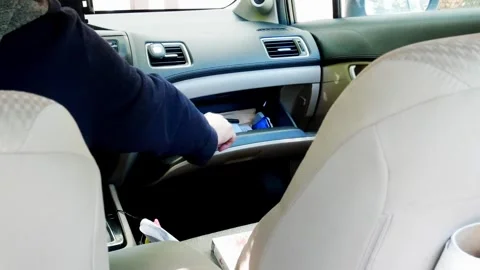 Man opens glove compartment in car to reveal gun Stock Footage 337539072