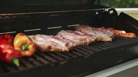 A man opens a grill. Pork steak, baked. Sweet pepper. 스톡 동영상 202137536