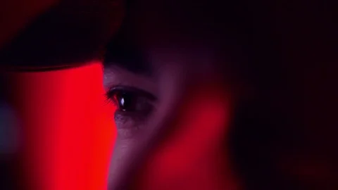 Man opens his eyes in close-up in neon red lighting Stock Footage 89368499