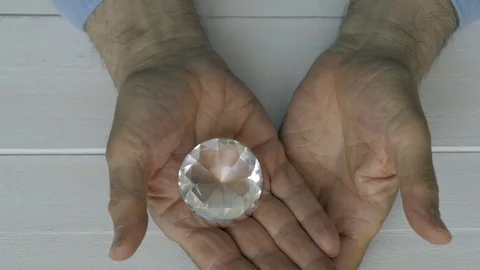A man opens his hand in which he hides a diamond Stock Footage 77659599
