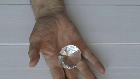 A man opens his hand in which he hides a diamond Stock Footage 77659605