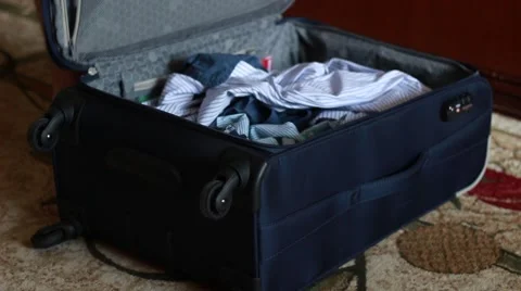 Man opens his suitcase and throws clothes out Vídeo Stock 63456300
