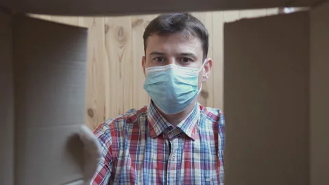 A man opens a home delivery box. Food delivery during quarantine. Vídeo Stock 129741912