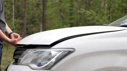 Man opens the hood of a car in the woods Stock Footage 155371241
