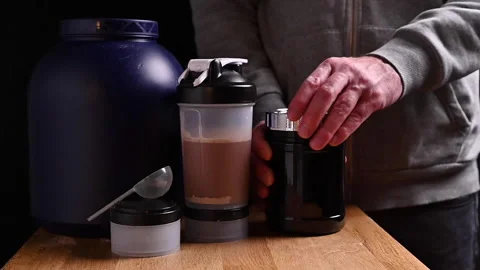 Man opens a jar of nutritional supplements with his hands. Sheker with a cocktai Stock Footage 145926551
