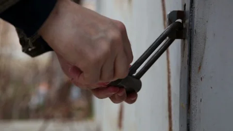 A man opens the key padlock.Hinged garage lock Stock Footage 105025877