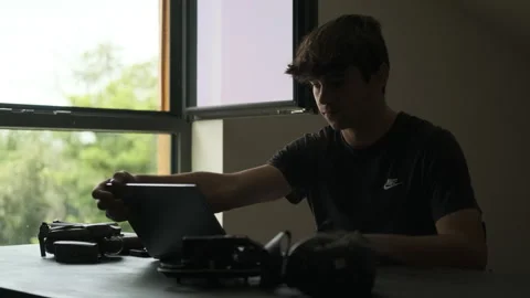 Man opens the laptop for editing. Silhouette. Filmmaker Edits. Drones next to it Stock Footage 243425293