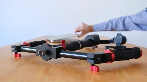 Man opens a laptop to read the instructions for a three-axis stabilizer Stock Footage 99641300