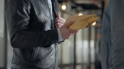 Man opens leather jacket, pulling out envelope with money and discreetly Stock Footage 304407370