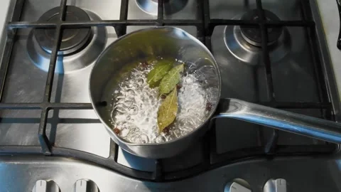 A man opens the lid with boiling water and bay leaves. Stock Footage 242333062