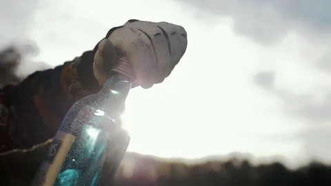 Man opens the lid of a glass bottle with crystal clear water Stock Footage 102654841
