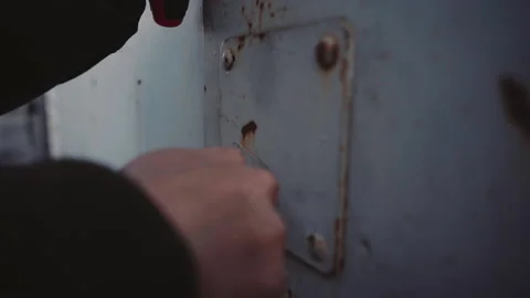 Man opens the lock on the heavy iron door with key Stock Footage 152422057