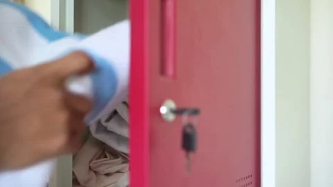Man opens locker to put blanket in Stock Footage 322205584