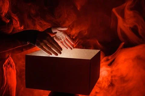 Man opens magic box with surprise on dark background, mystical box, surpris.. Stock-Fotos