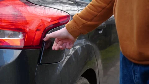 Man opens man opens the hatch of the gas tank of the car Stock Footage 271068792